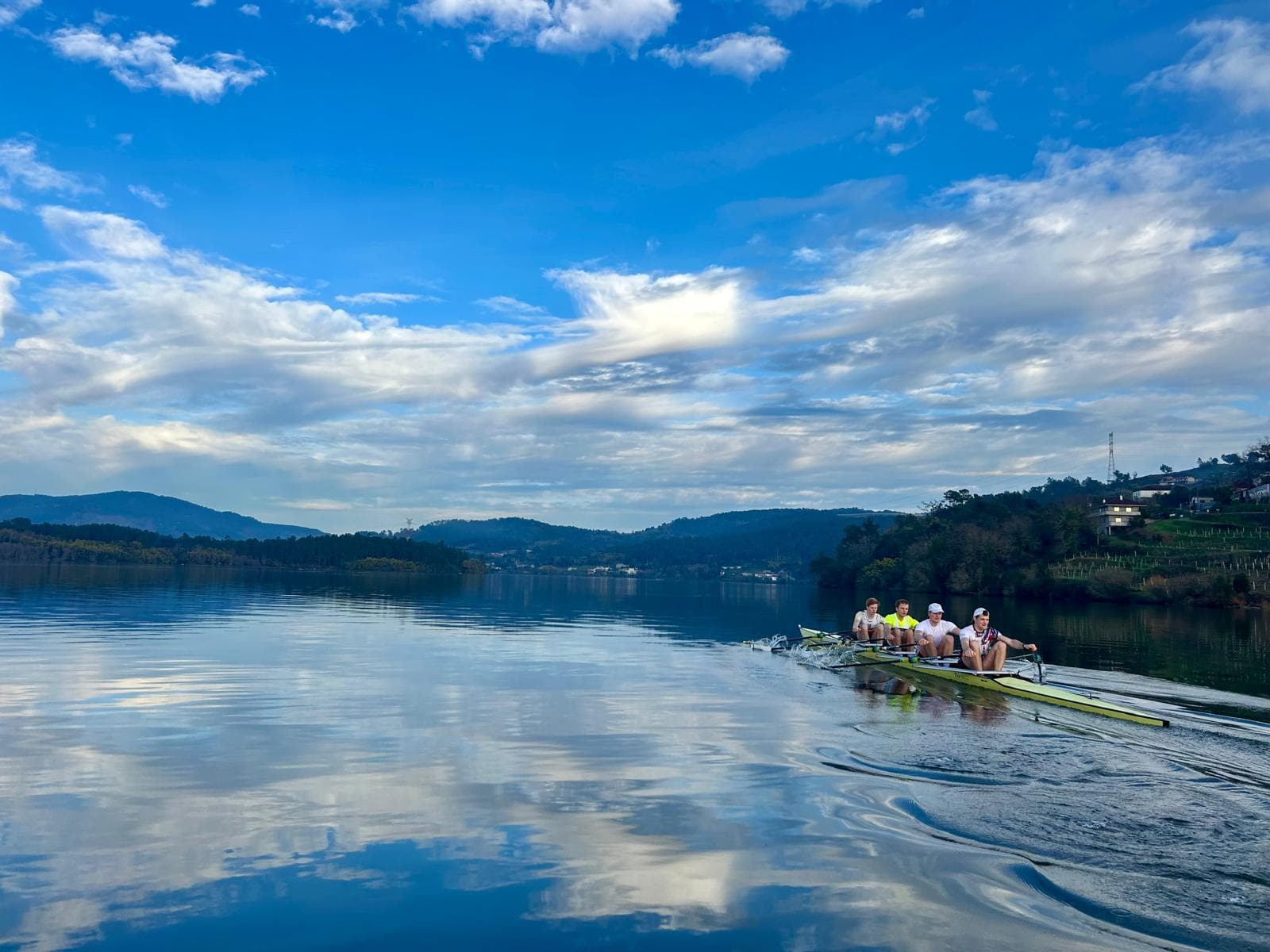 Four-person crew on a mirror-calm river